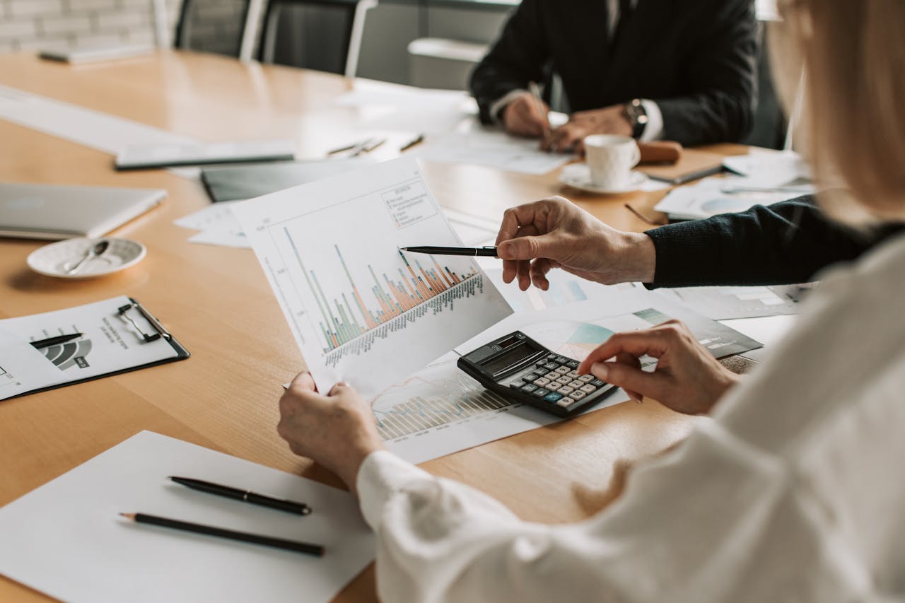 heros-img Professionals reviewing financial graphs and charts during a meeting.